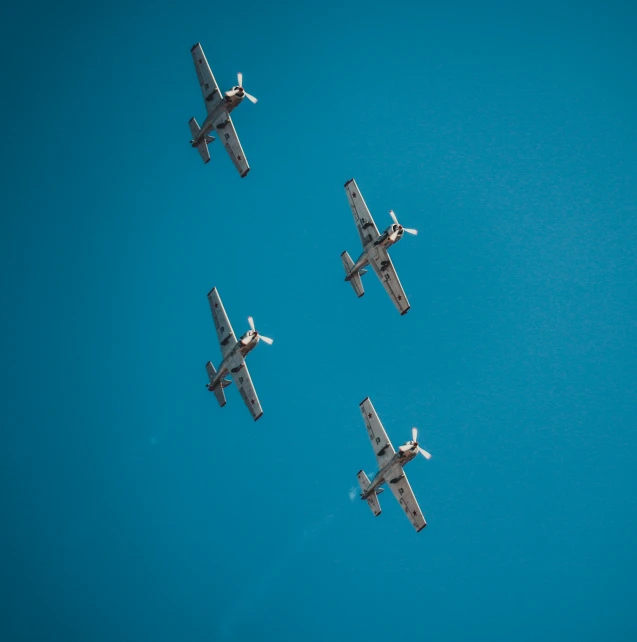 four airplanes flying side by side in the sky