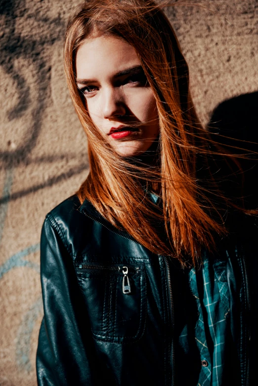 a beautiful young lady standing with long red hair