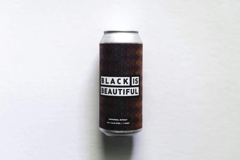 a can of black is beautiful sits on a white surface