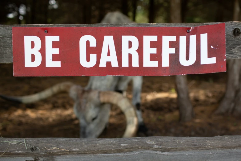 a sign hanging from the back of a wooden fence