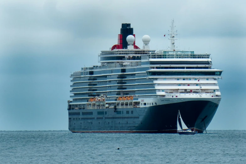 a cruise ship is in the ocean near another boat