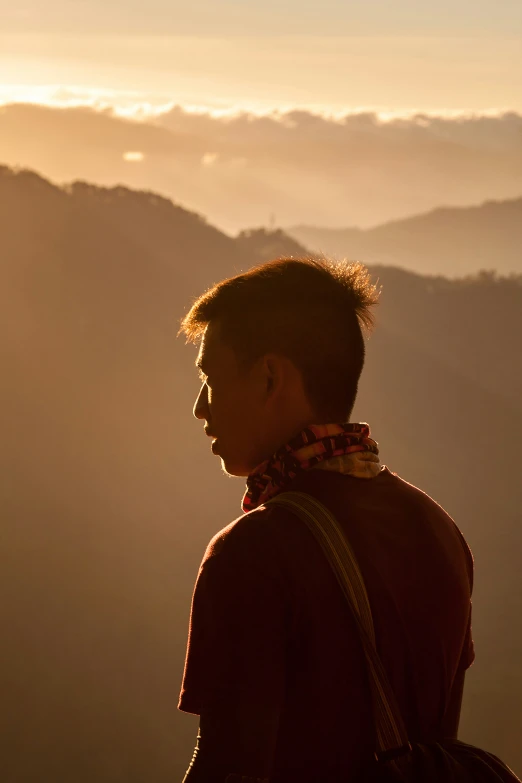 a person with backpack looks at mountain range