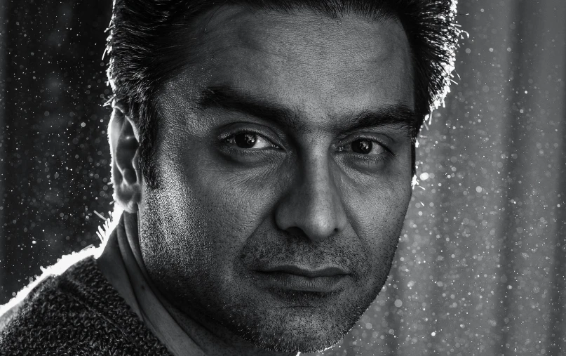 man in suit jacket posing for picture with raindrops