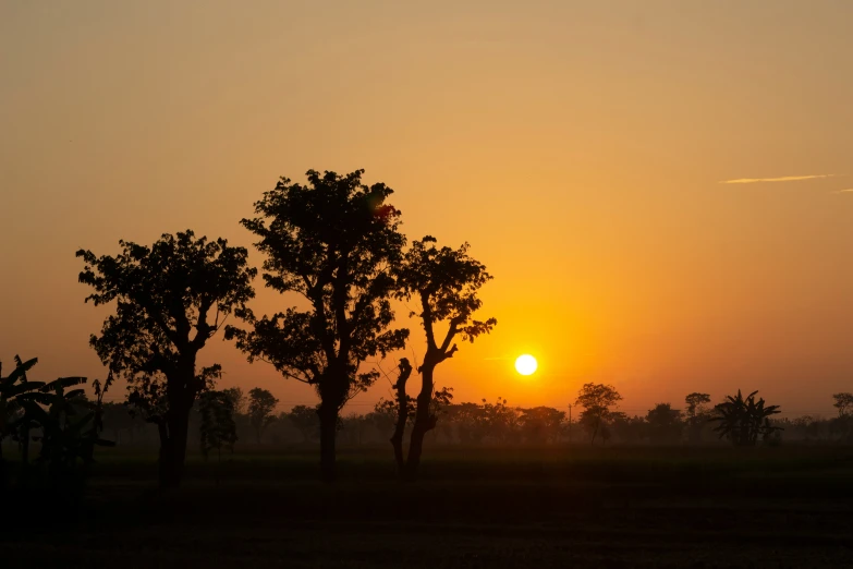 the sun sets in a setting in an area of barren land