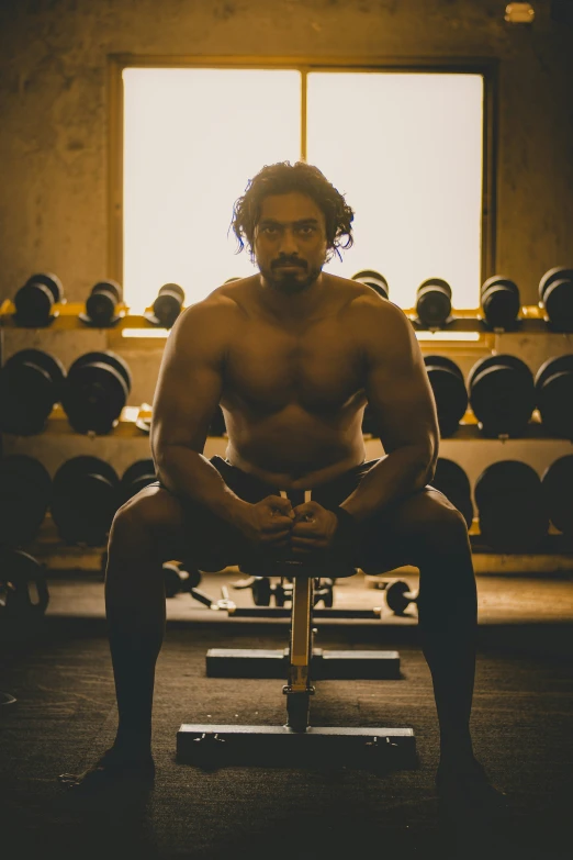 man with  on sitting on a bench in a gym