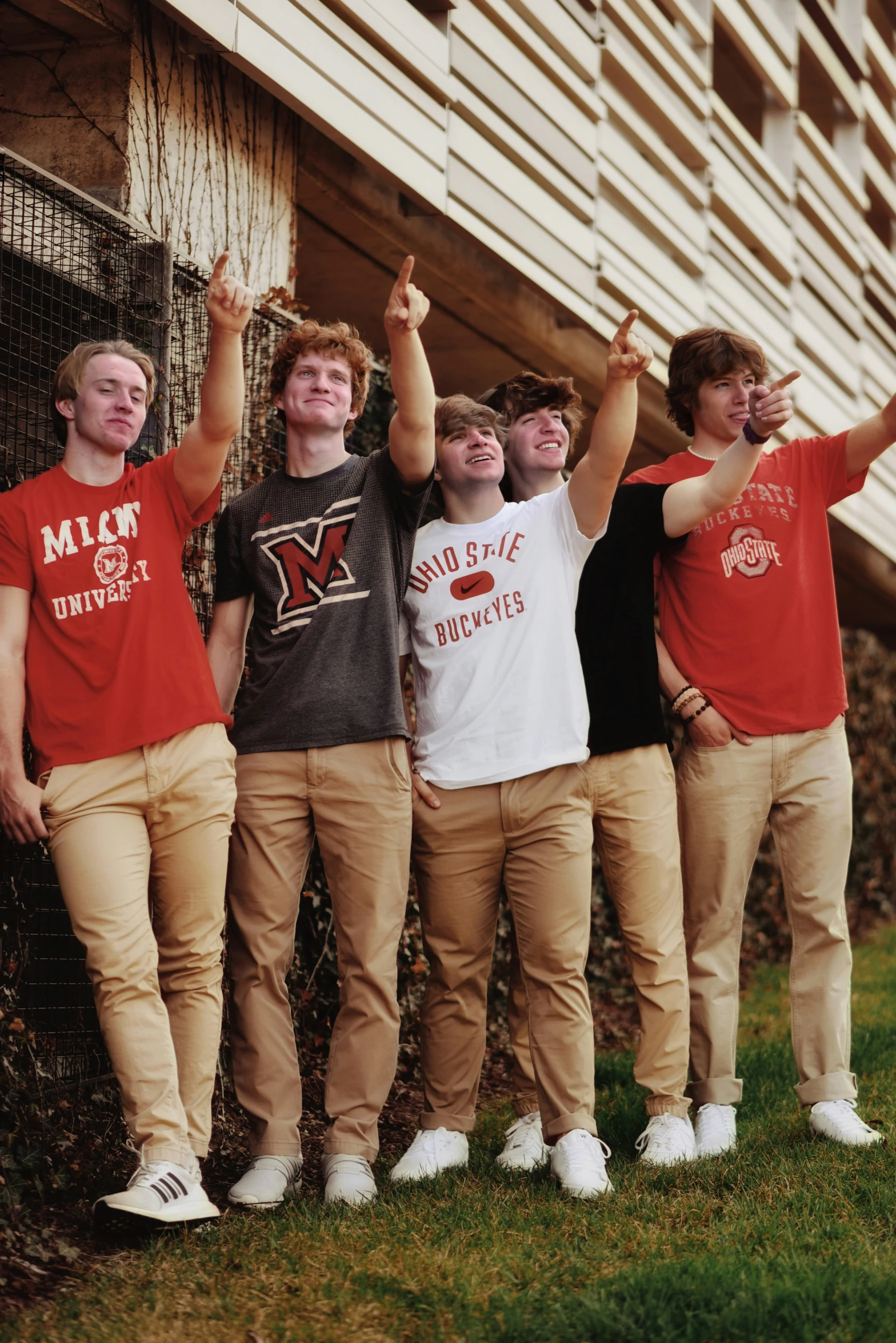 five young men standing together outside the school building