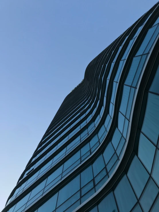 a plane flying in the sky near to a very tall building