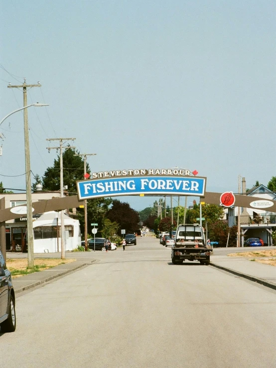 some cars are going down a street with a sign