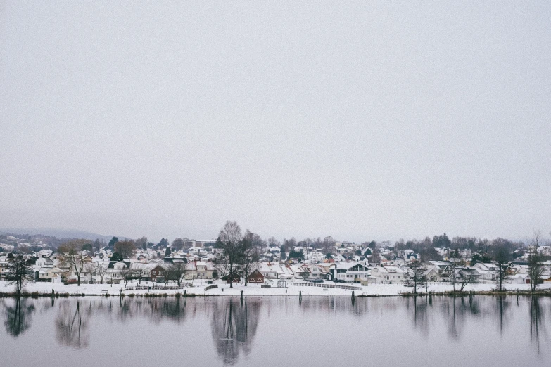 snow covered buildings near the waters on a sunny day