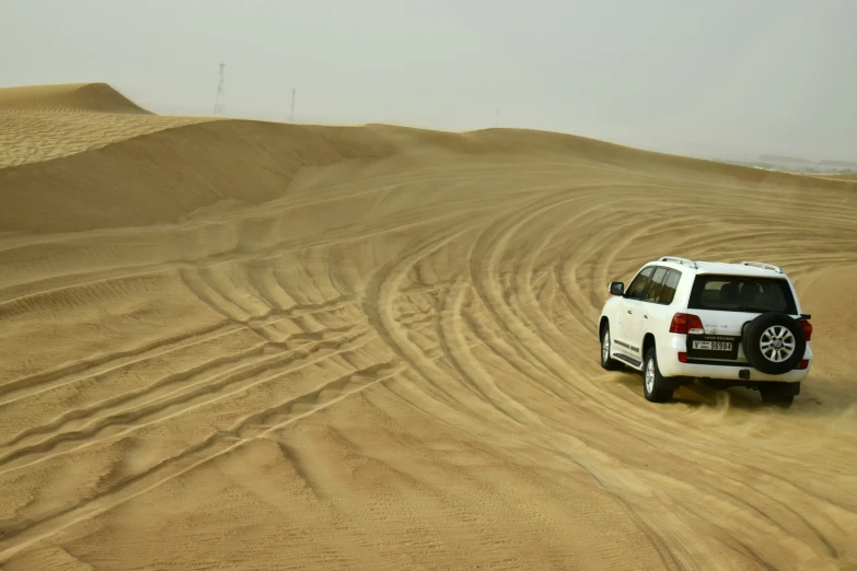 a white four door car in the desert