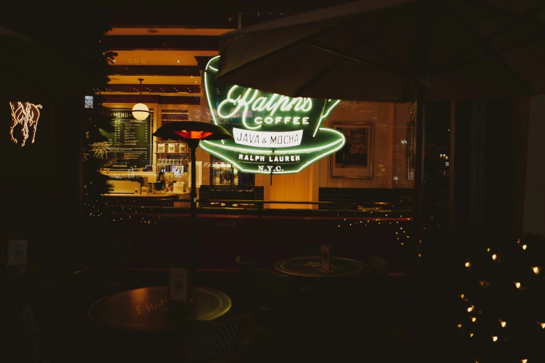 a restaurant sign is lit up against the night sky