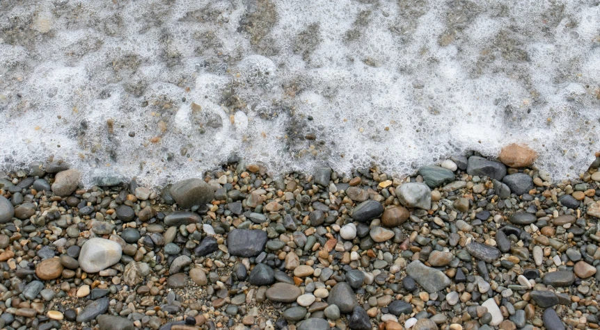 some rocks and gravel in front of water