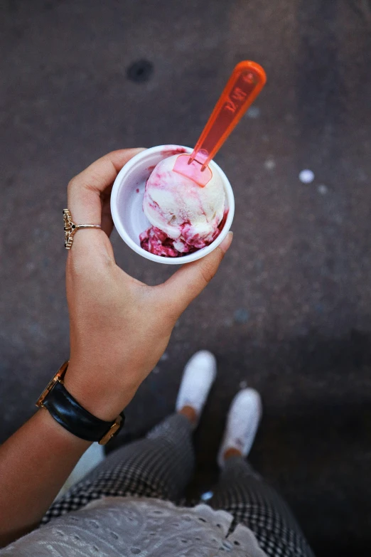 a close up of a persons hand holding an ice cream