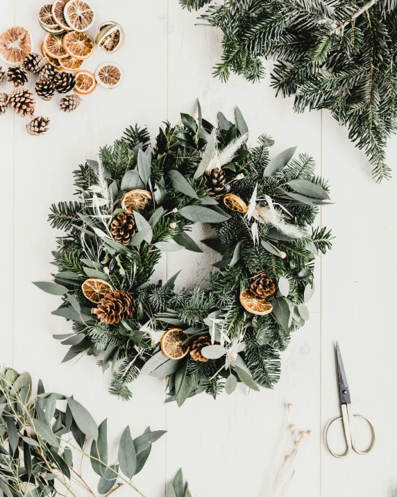 a wreath on a table surrounded by other christmas items