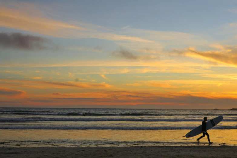 the surfer is carrying his surfboard into the water