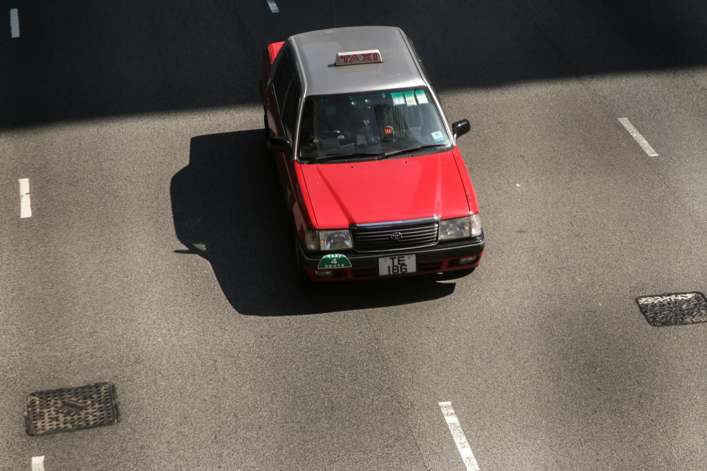 an aerial view of a red car driving on the road