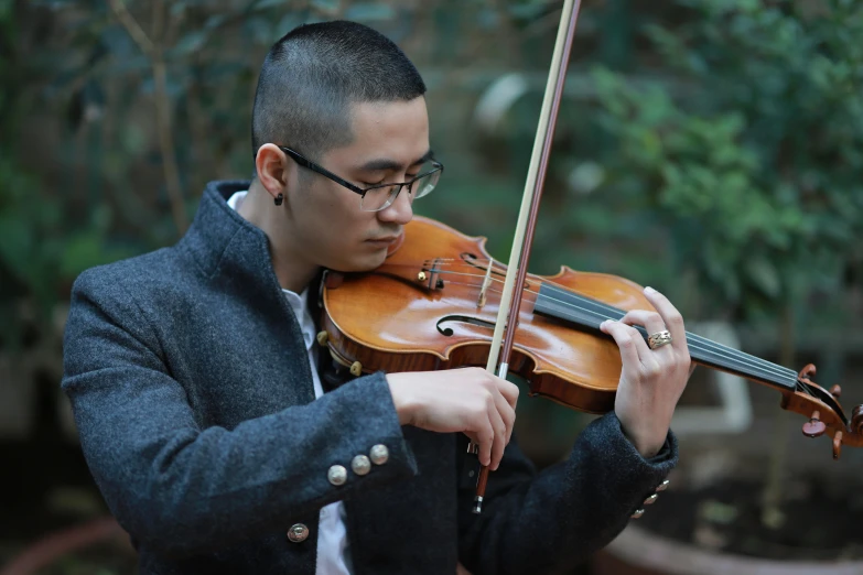 a man is playing the violin and wearing glasses