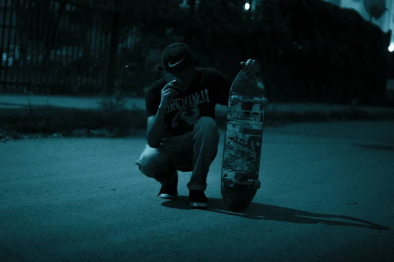 a person kneeling with a skateboard next to a pole