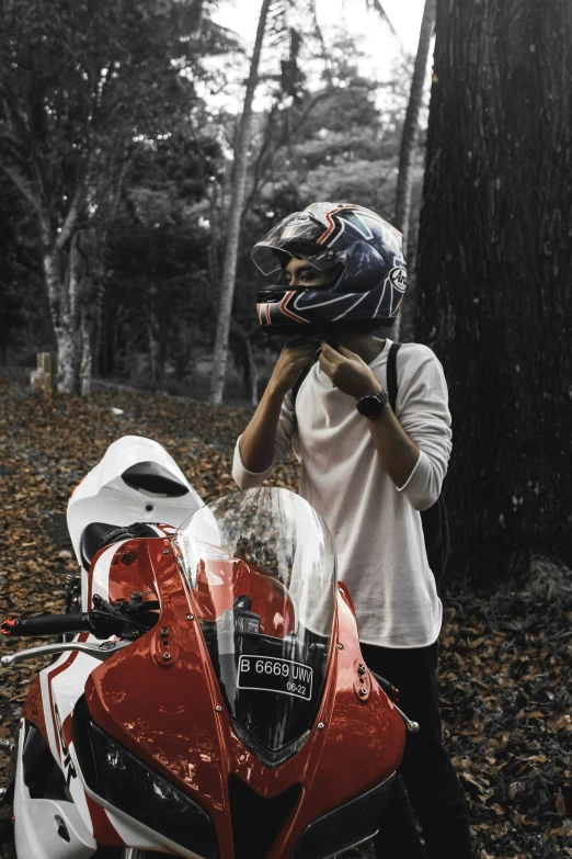 a person with a helmet standing next to a motorcycle