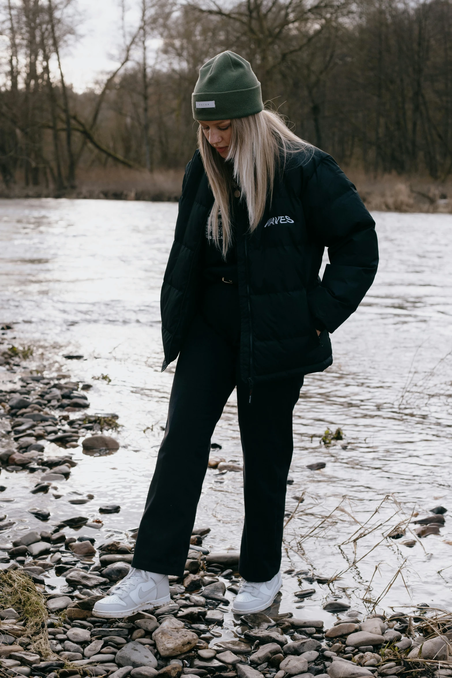 a person standing on rocks by a river