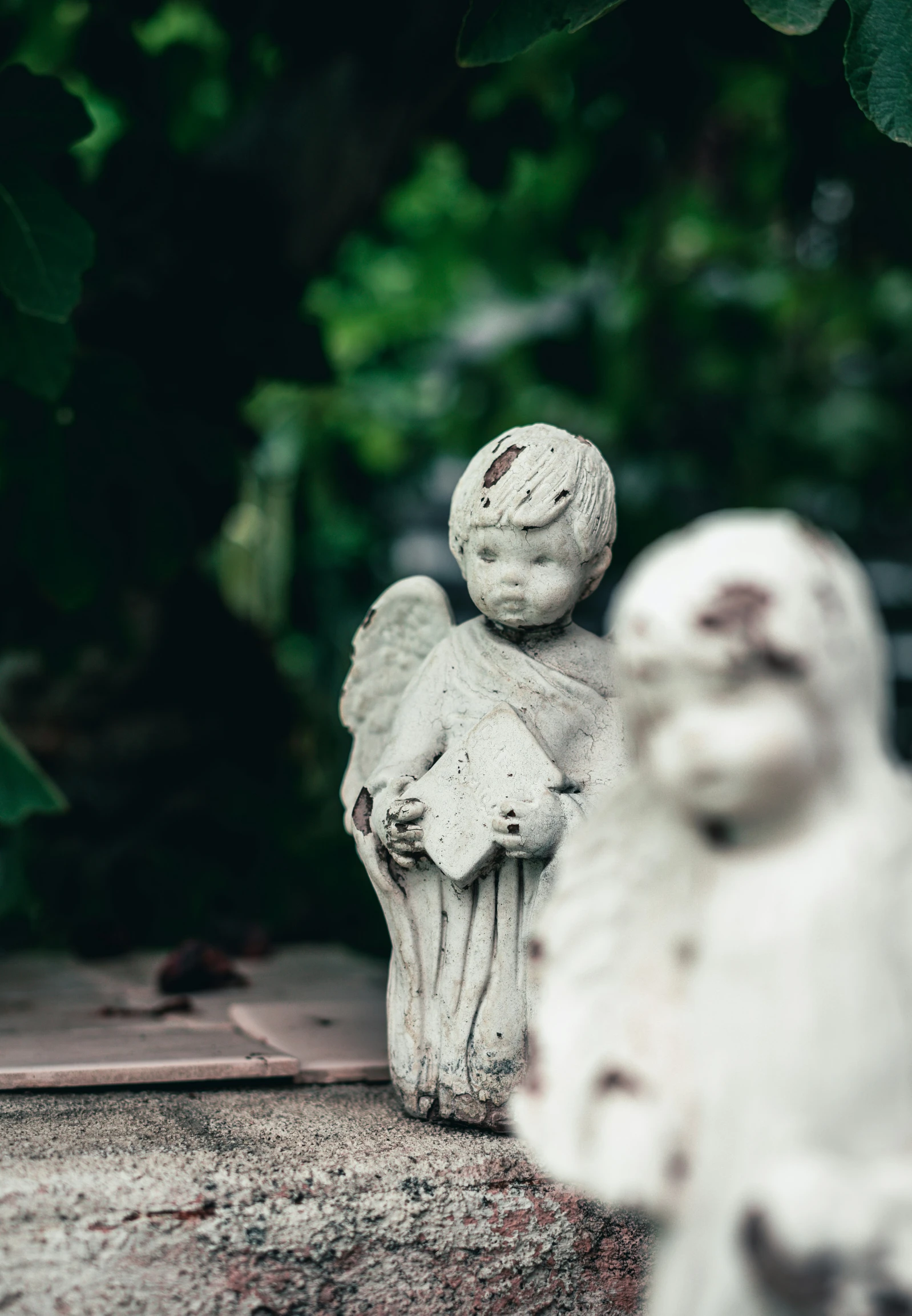 some very cute white angel statue sitting in front of trees