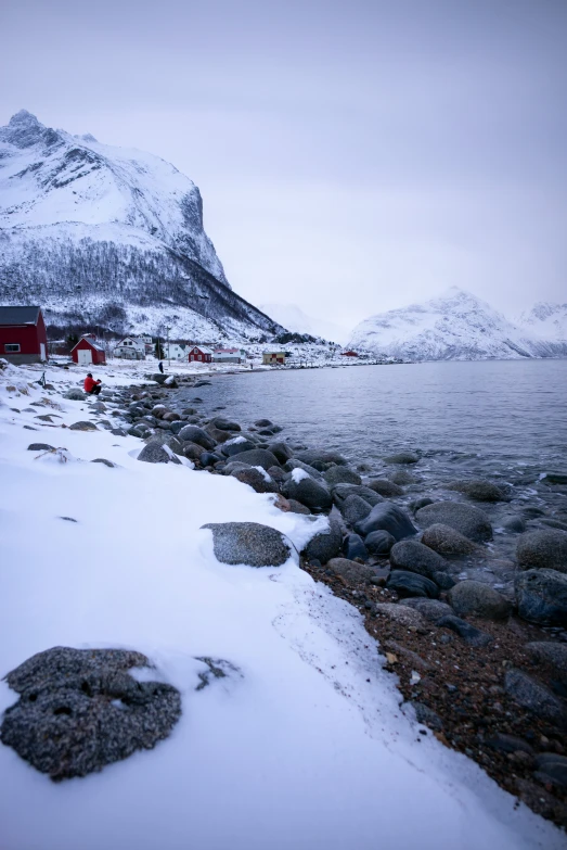 a couple of rocks near water and snow