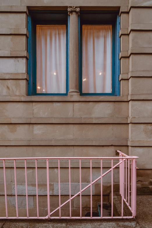 a pink gate and a window sitting on the side of a building