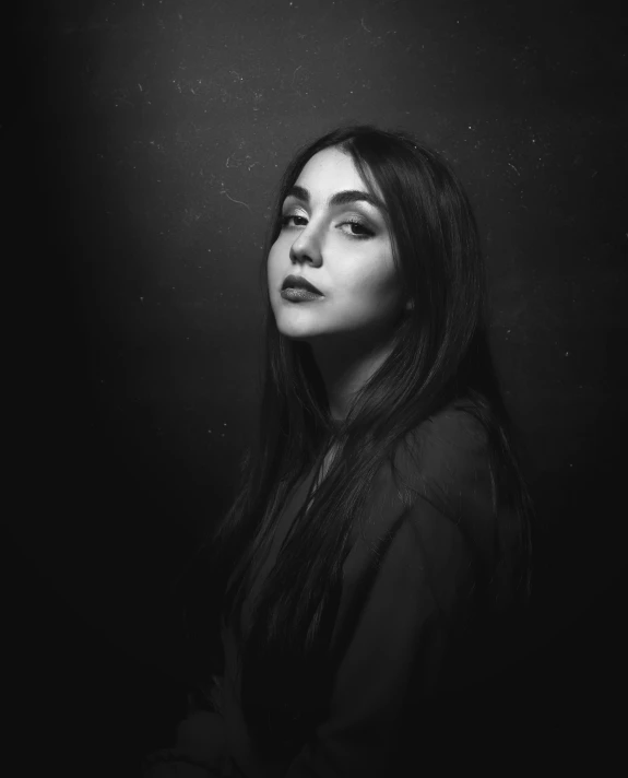 woman looking up while standing in front of dark background