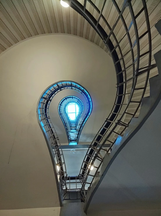 a spiral staircase with blue light is shown