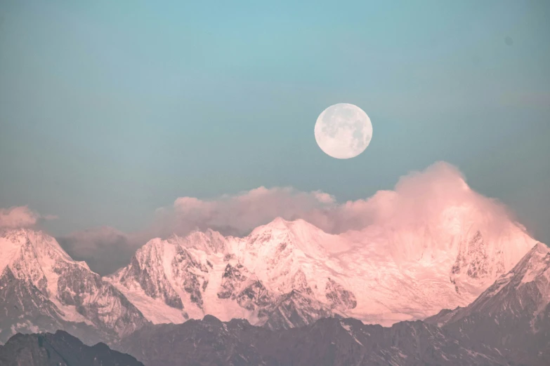 the moon shines brightly behind some very tall mountains