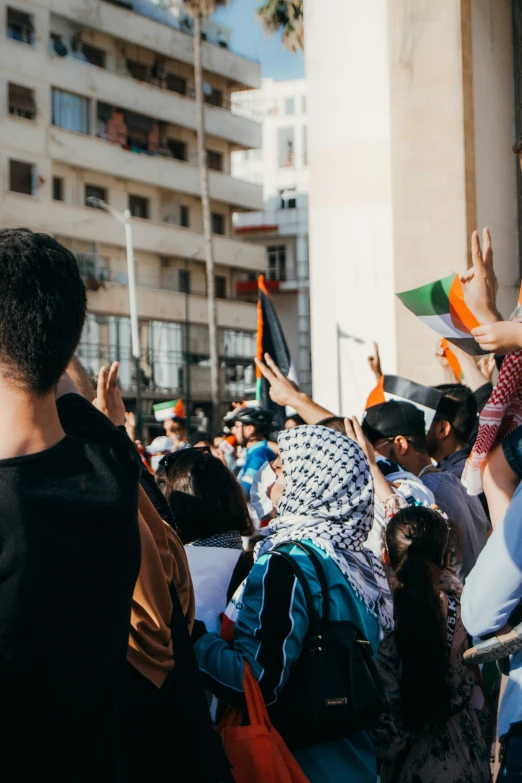 a man is surrounded by crowd waving a flag