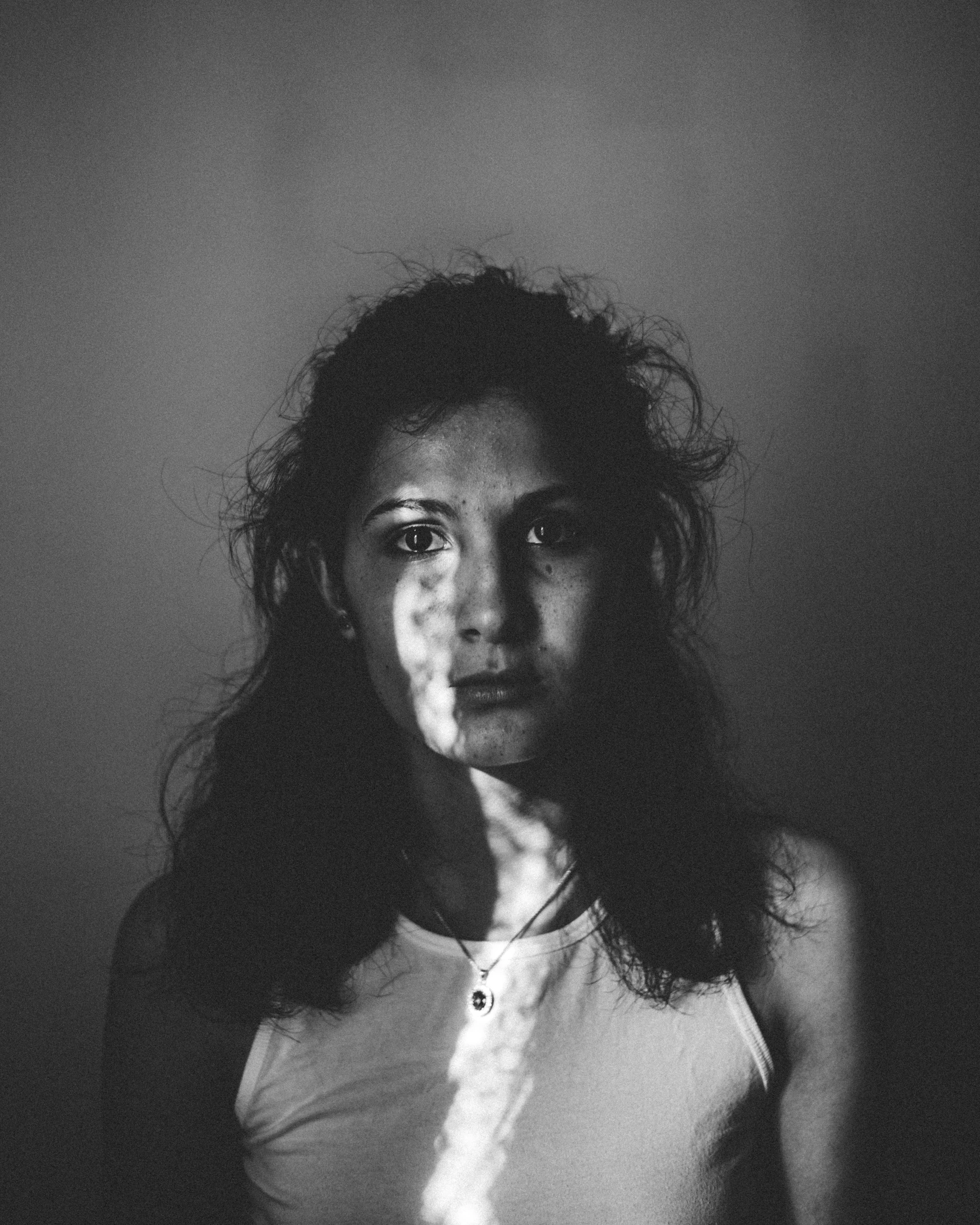 a woman standing and smoking in a dark room