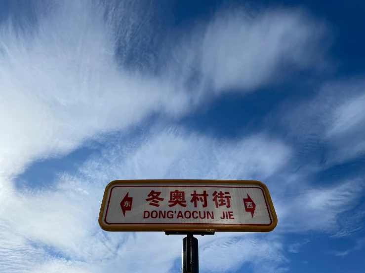 the sign is written in chinese on a street pole