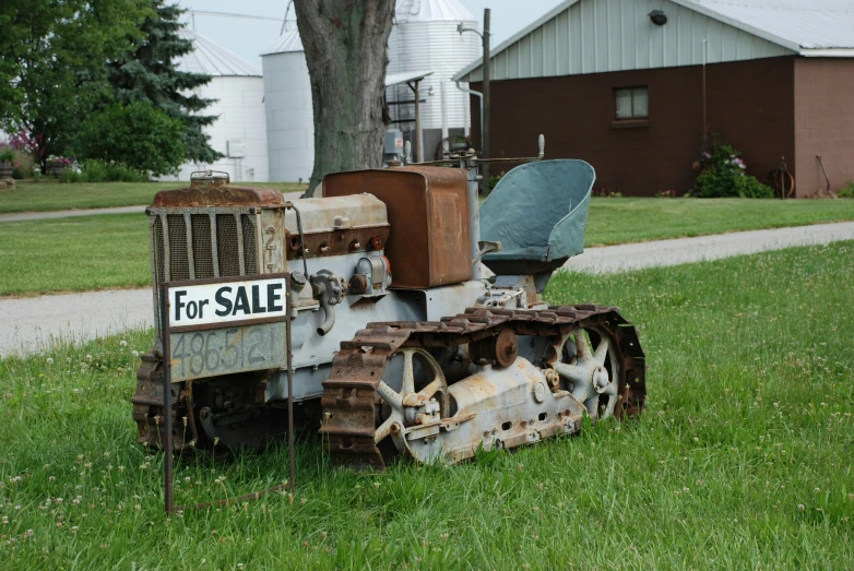 an old bulldozer is left out on the grass