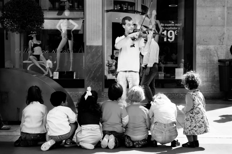 a man is holding a tennis racket near some children