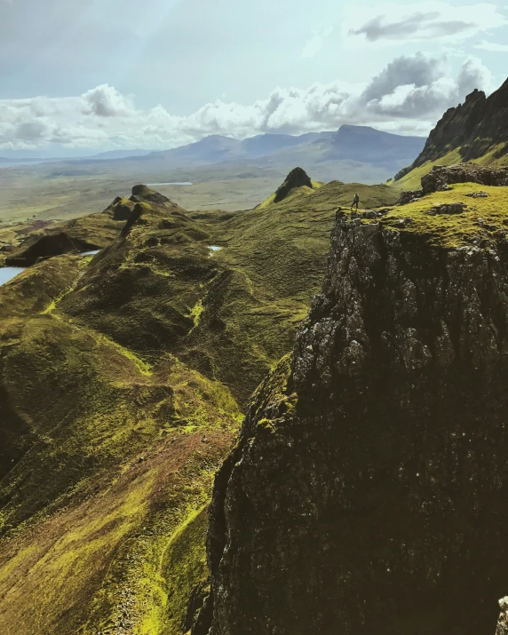 a rocky hillside with a body of water near the mountains