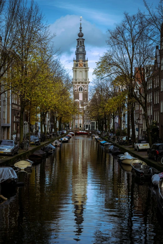 a waterway next to buildings with boats and trees around