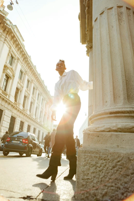 man standing next to a pillar in the street