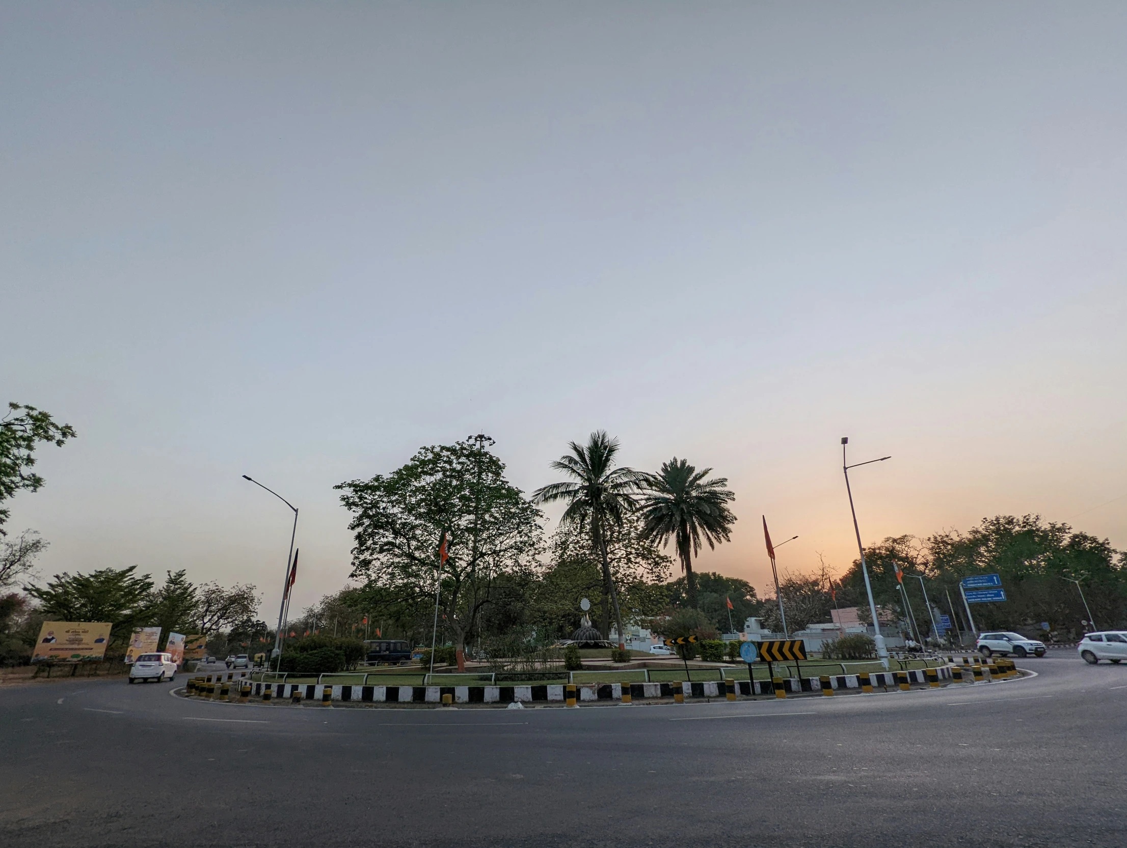 a road near some palm trees and a small building