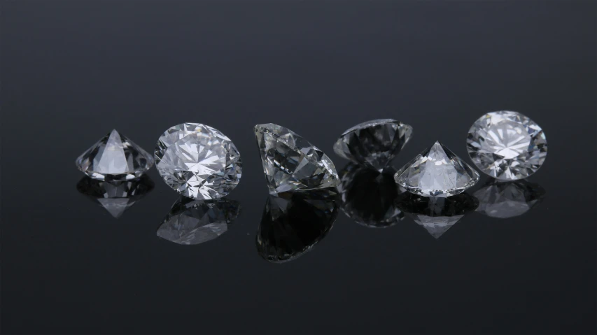 five shiny and clear diamonds on black surface