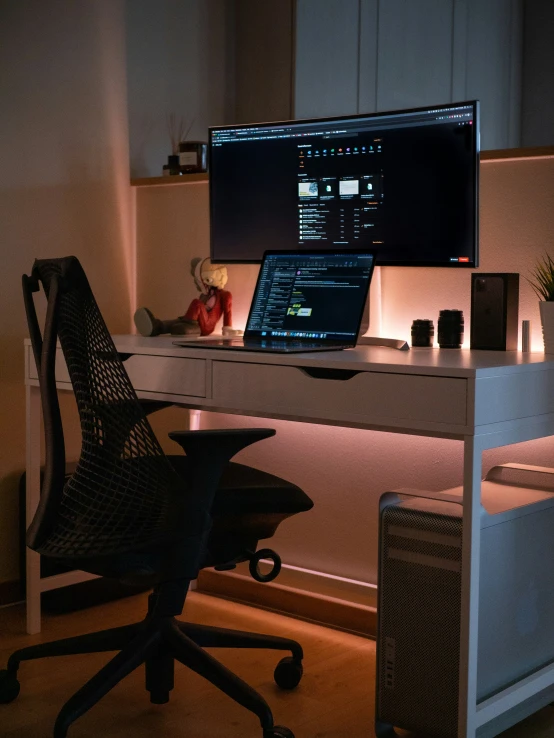 computer on a desk in front of a monitor