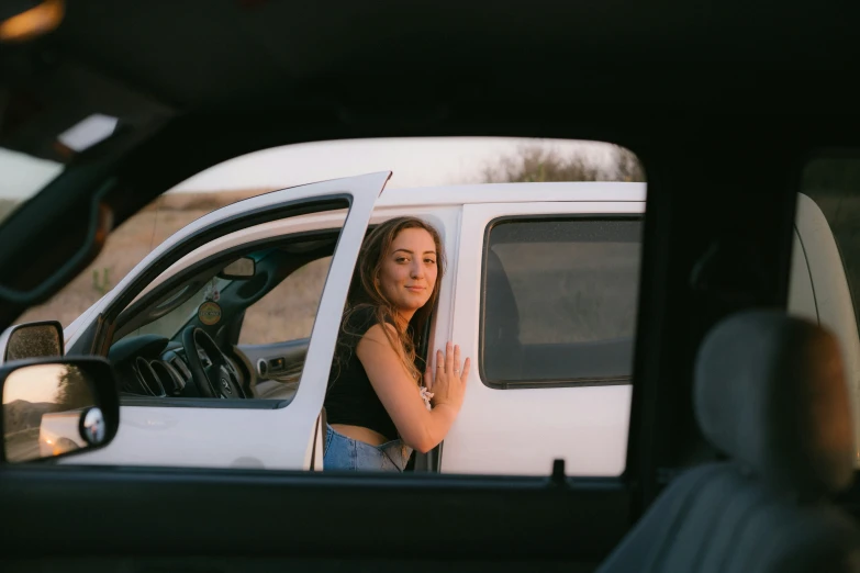 a beautiful woman looking out the window of a white truck