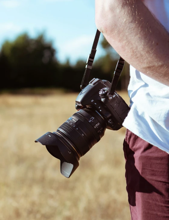 the pographer holds a camera for the lens to be pointed at