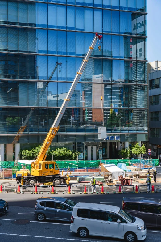 a large construction crane with a big building in the background