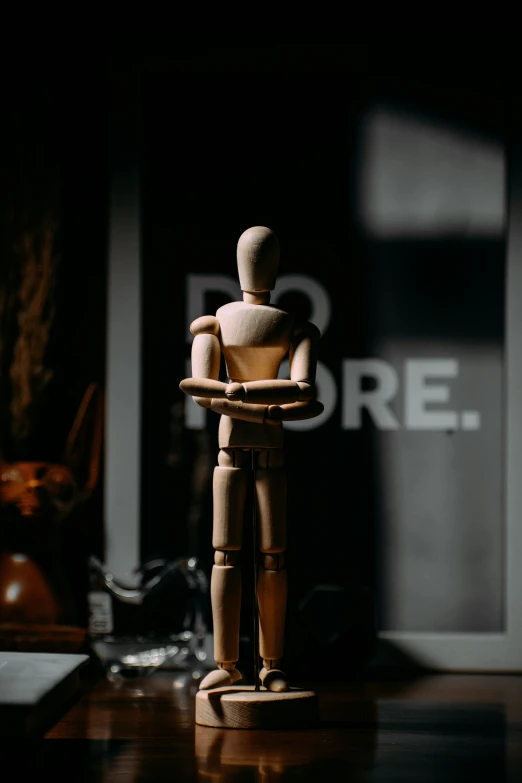 a toy is on a wooden desk near a black backdrop