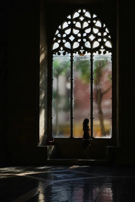 a person sits next to a stained glass window