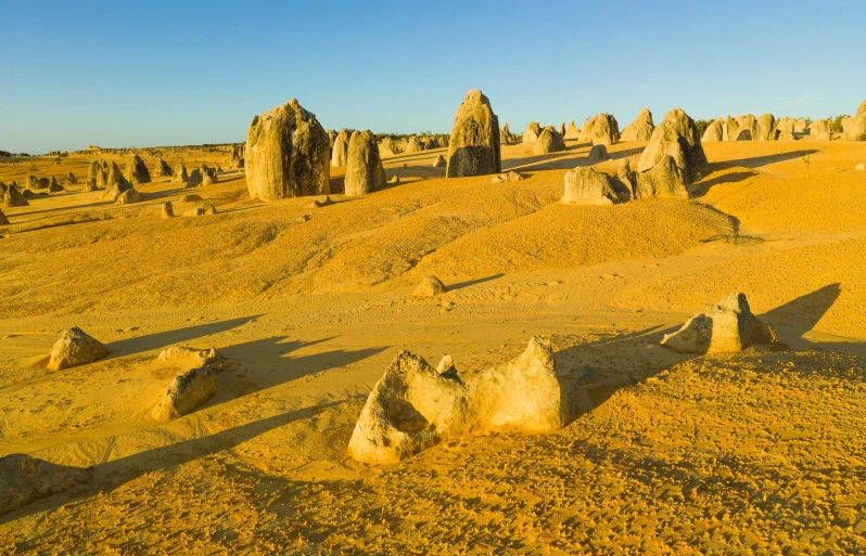 rock formations in a barren plain with blue skies