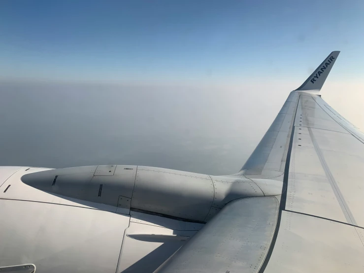 the wing of an airplane over some water