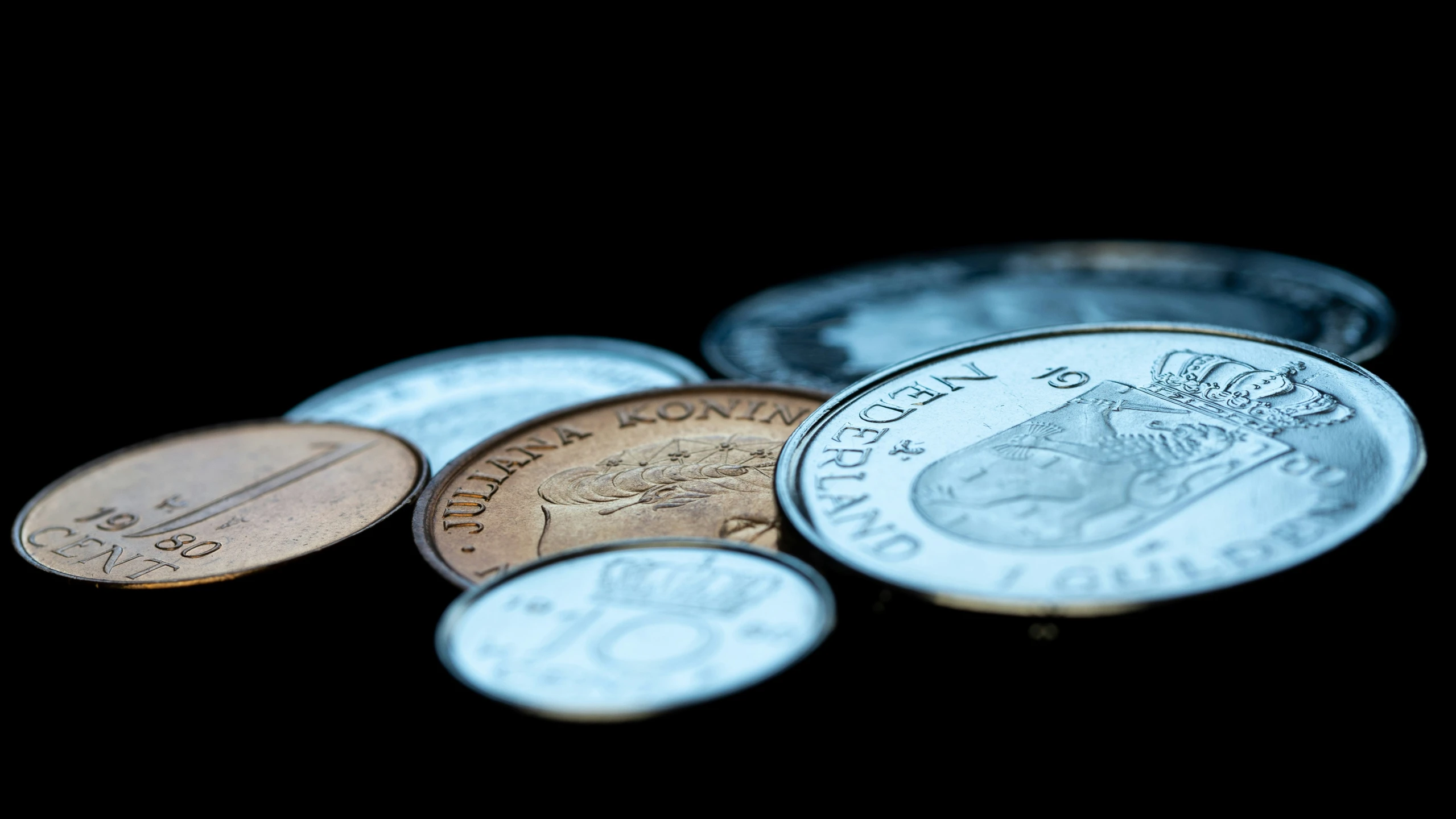 close up of many coins on a dark table