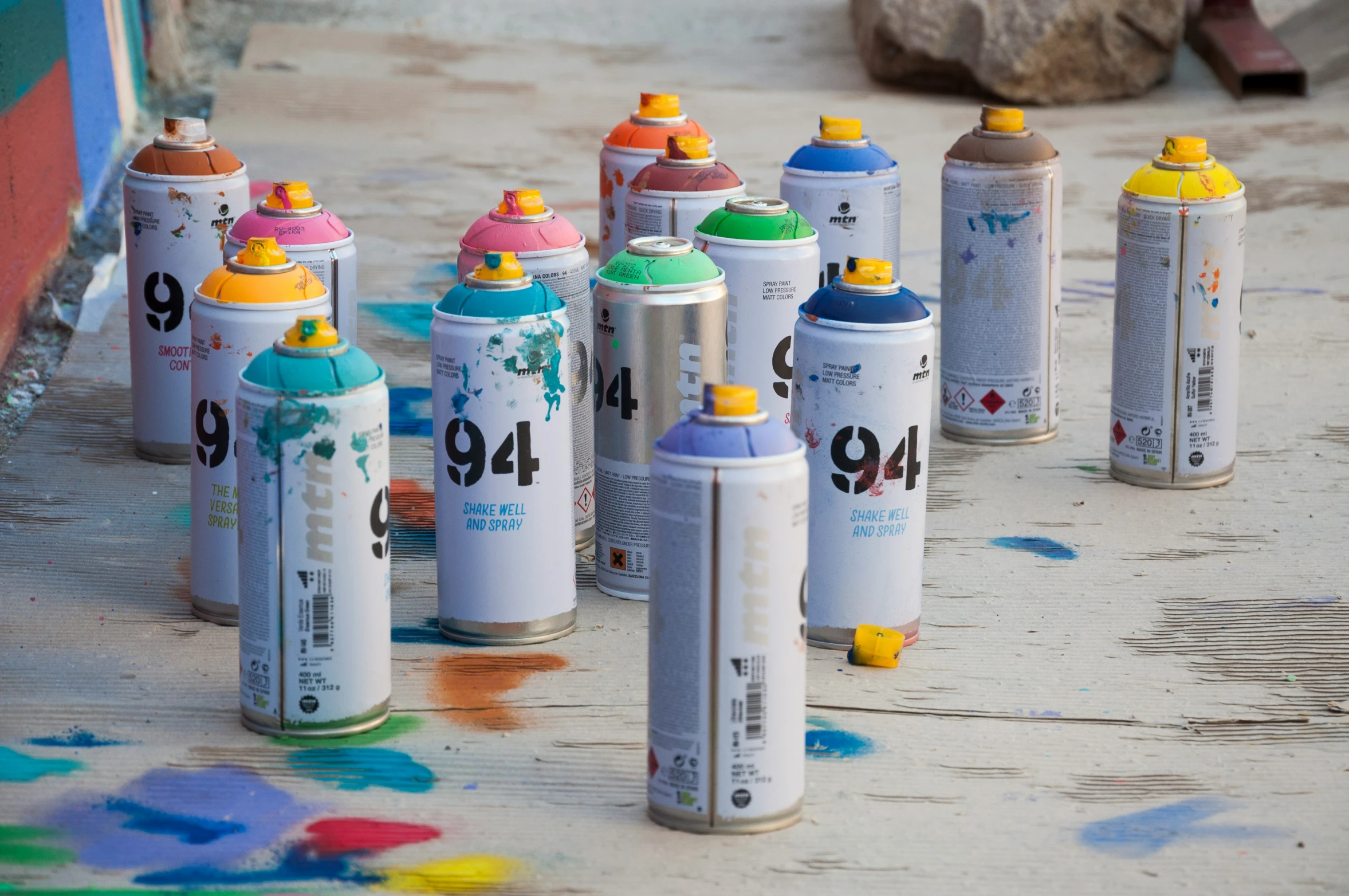 nine spray paints next to each other, lined up on the ground